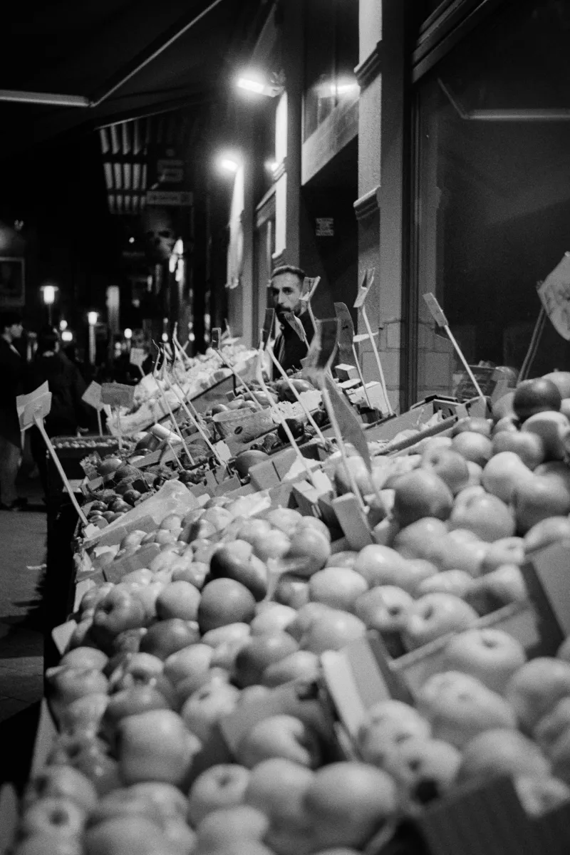 Winter evening vegetable stand with wooden crates of produce displayed in front