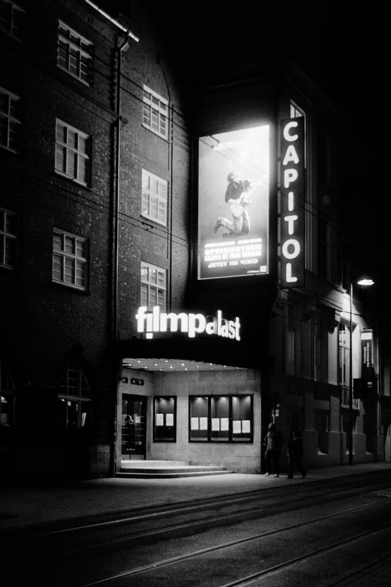 Capitol cinema entrance with illuminated filmpalast sign at night