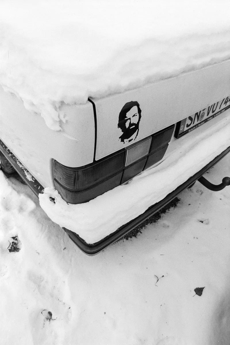 Close-up of a snow-covered car with a Bud Spencer sticker.